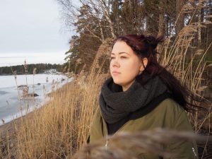 Emmi Inberg seisoo meren rannassa ja katsoo ulapalle.