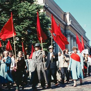 Vappumarssi etenemässä Helsingissä Unioninkadulla Yliopiston kirjaston luona joskus 1950-luvulla. Marssijoilla on käsissään punaisia lippuja.